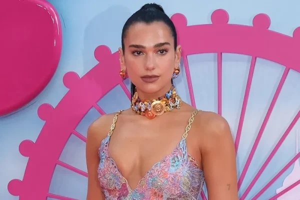 Dua Lipa in pink with hair tied in a ponytail